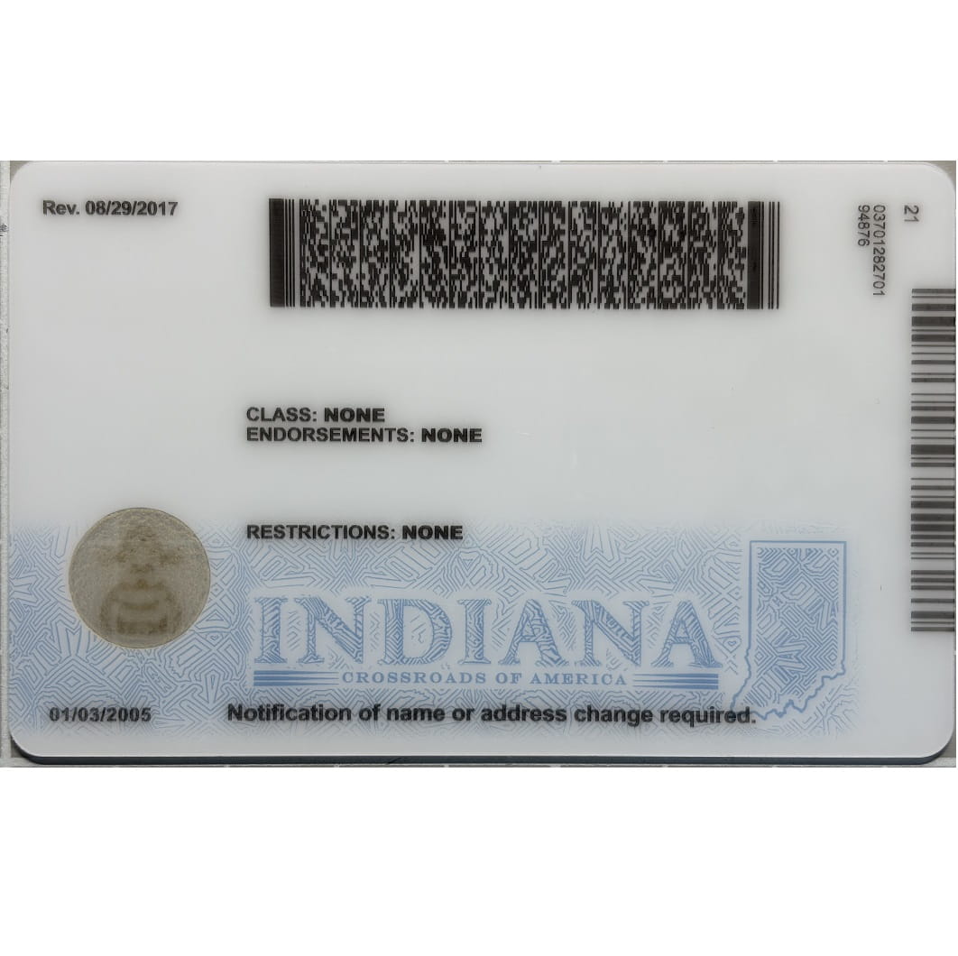 A replica or sample Indiana driver's license card shown flat against a white background, featuring black barcodes, printed text, and a blue-iridescent lower section with the word INDIANA.